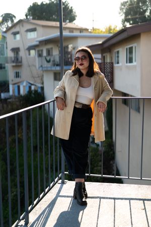 Full length of stylish young woman leaning on balcony