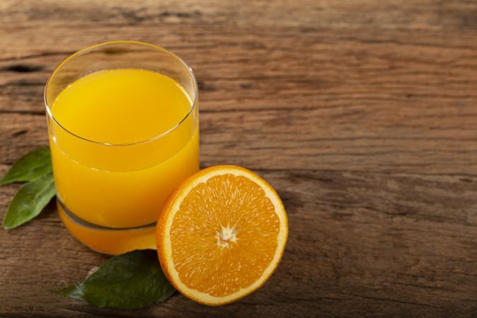Glass with orange juice on the table.