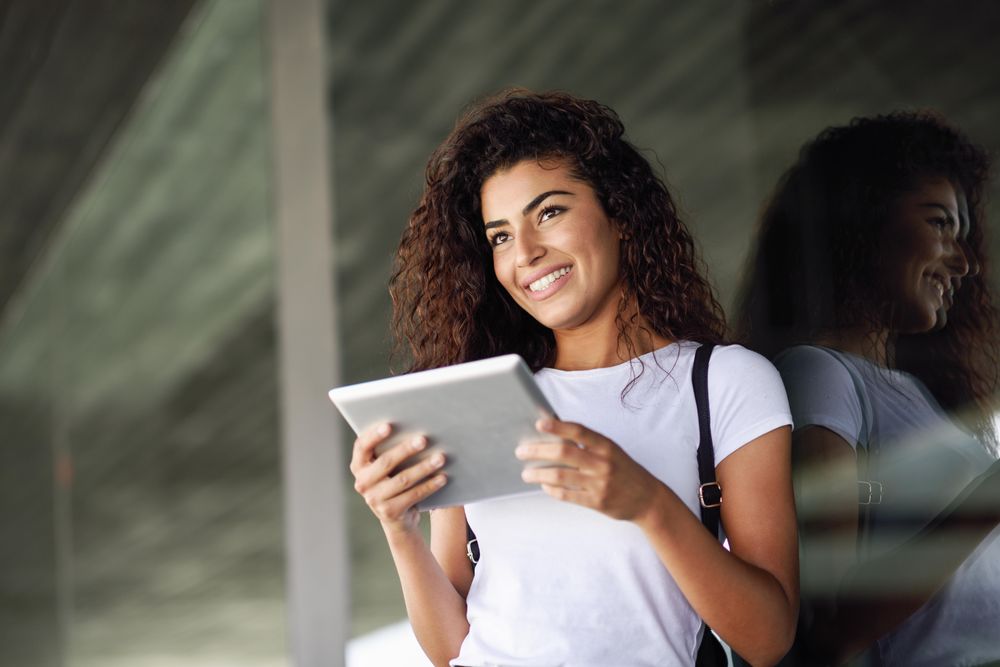 Arab woman using digital tablet in front of office building