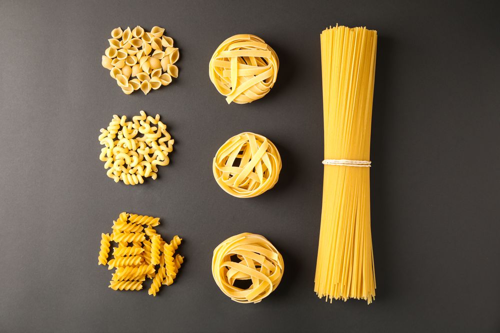 Flat lay composition with pasta on dark background, space for text