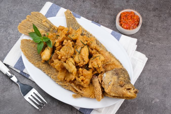 Gurame Saos Telur Asin. Crispy fried gourami fish covered with salted egg sauce. Indonesian food