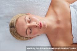 Blonde woman lying back before facial treatment bGRW8e