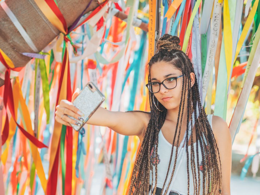 young woman using smartphone outside during festival
