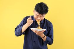 Young Asian Man Enjoy Instant Noodles with Happy Face