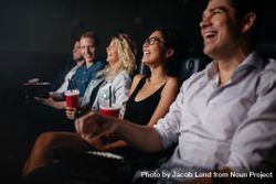 Group of friends laughing while watching a movie 4Nk72b