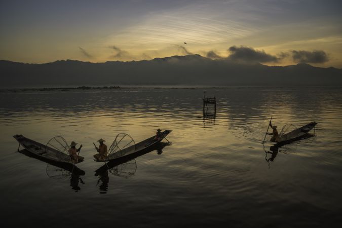 Fishermen on their boats at sunset in Myanmar