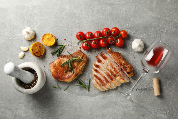 Composition with fried steaks, wine and vegetables. Grilled food