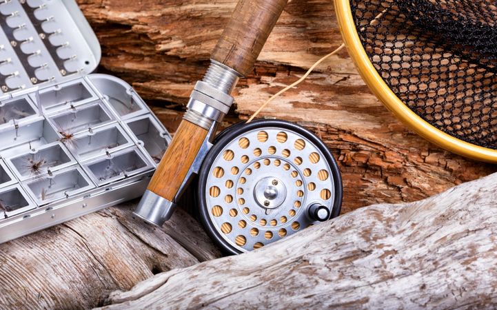 Vintage fly fishing outfit and gear on rocks and drift wood