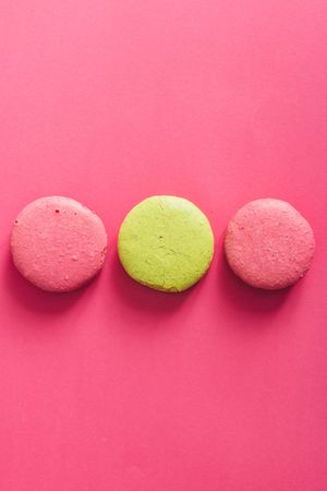 French macaron in rows on bright pink background
