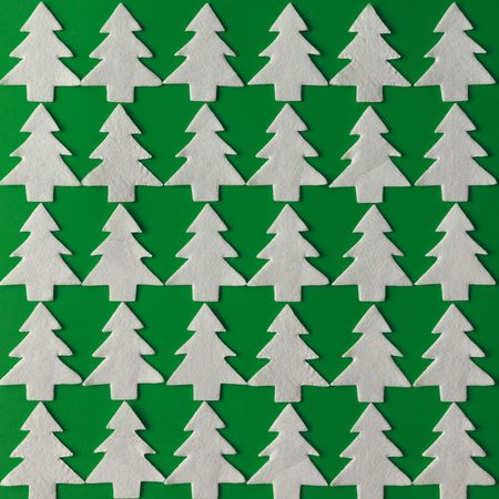 Pattern made of felt Christmas trees on green background