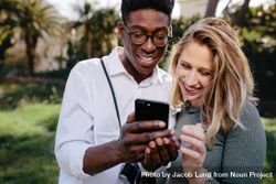 Young man and woman looking at photos on mobile phone 0y61O5