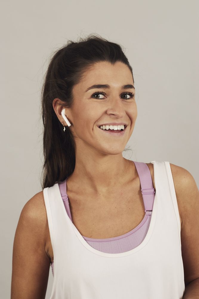 Female athlete listening to music in studio