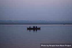 Silhouette of three people on boat on body of water during a cloudy day 41nYOb