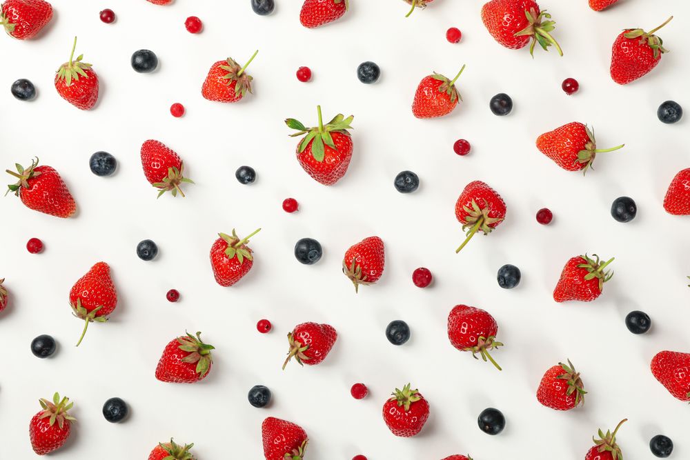 Flat lay with tasty strawberry and blueberry on plain background, top view. Summer berry