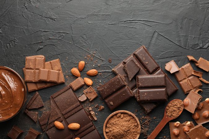 Chocolate, melted chocolate and almond on dark background