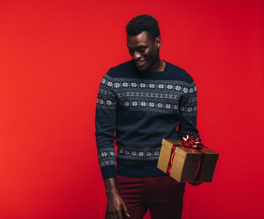 Young Black guy holding a gift box