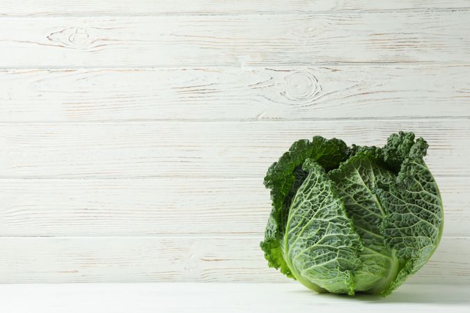 Fresh cabbage on wooden background, space for text