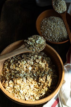 Wooden bowls of dry oats on kitchen counter