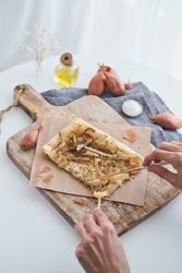 Faceless person cutting onion tart