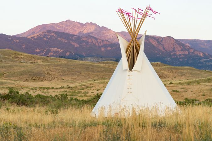 Montana, United States - August 17, 2022: Teepee in front of Rocky Mountains at sunset