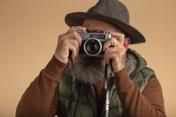 Hipster tourist photographer isolated holding a camera