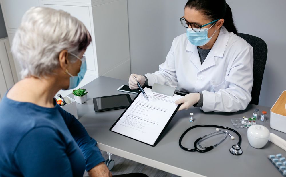 Doctor explaining to her patient consent form to coronavirus vaccine