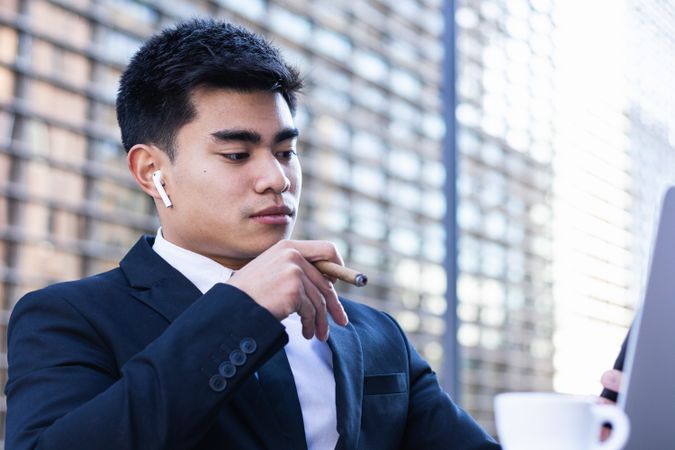 Businessman smoking cigar in street cafe