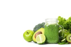 Green vegetables, fruits and jar of smoothie isolated on blank background