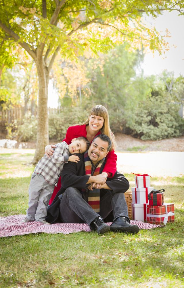 Family Enjoying Christmas Gifts in the Park Together