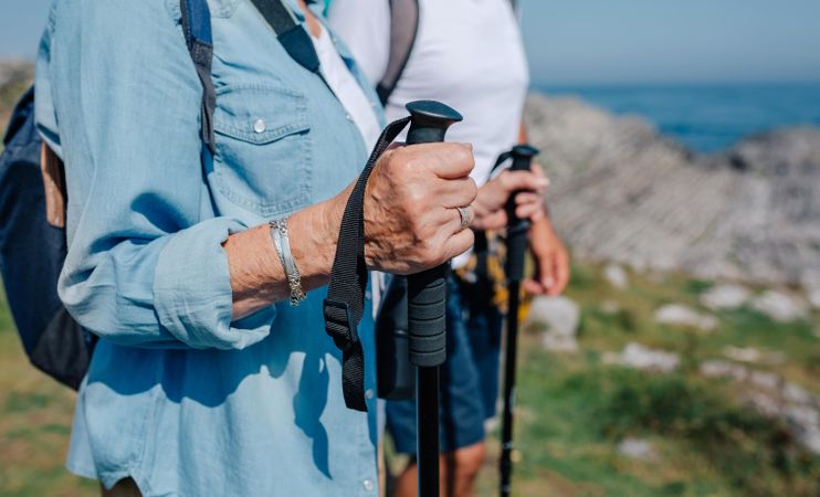 Close up of people holding trekking poles