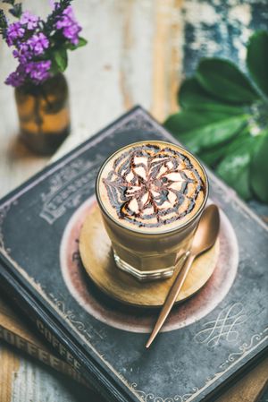 Top view of latte with decorative pattern in chocolate syrup on coffee book