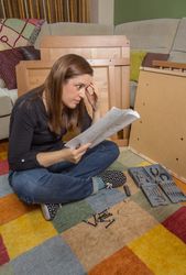Woman reading instructions to assemble furniture