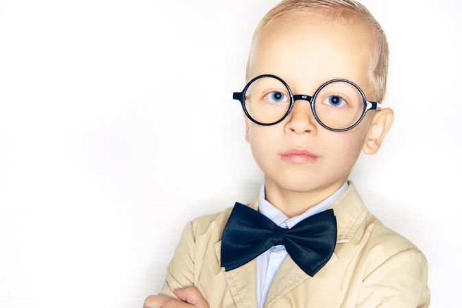 Serious blond boy in spectacles and bow tie
