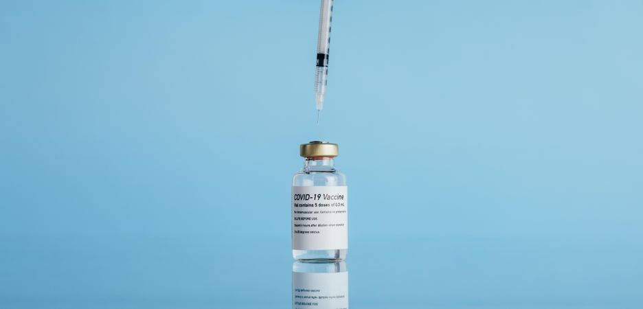 Vial with a syringe on reflective surface