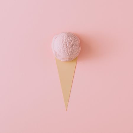Ice cream scoop on pastel pink background with paper cut out cone