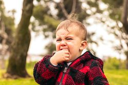 adorable baby boy crying in a park