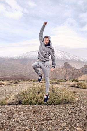 Happy man jumping with fist up while celebrating triumph