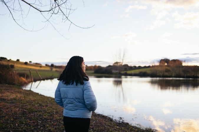 Woman watching the sunset on a lake