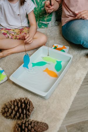 Family camping at home playing fishing game