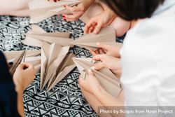 Group of women making paper planes 0LAnV5