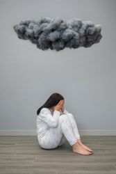 Unrecognizable woman under a dark storm cloud