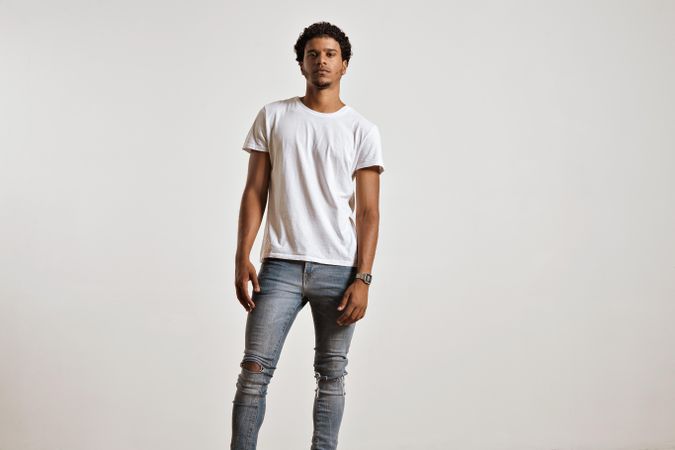 Portrait of serious man with plain t-shirt and skinny jeans in studio shoot
