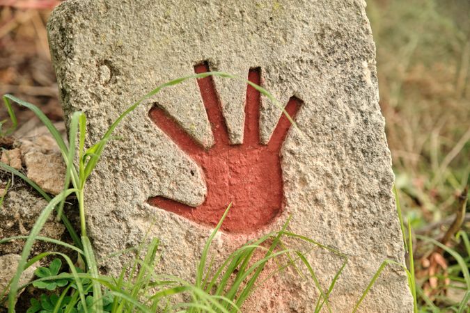 Red hand print on stone surface