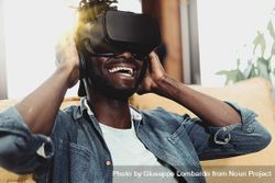 Black man with VR googles smiling reacting to metaverse experience 4NEaKe