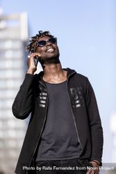 Black smiling man with sunglasses using mobile phone outdoors 5wXLOm