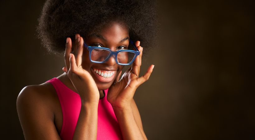 young Black woman with afro hairstyle happy smiling in glasses