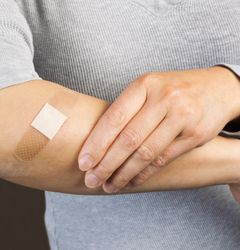Bandage covering cut on person’s forearm