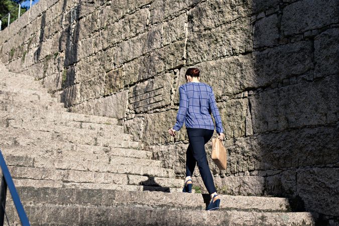 Businesswoman climbing up street stairs