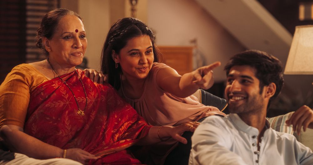 Portrait of Happy Indian Family Enjoying Movie Playing on TV at Home Together.