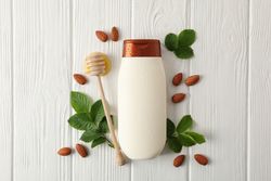 Natural hair care. Blank shampoo bottle and natural ingredients on wooden background